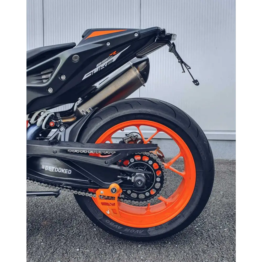 Motorcycle rear wheel with orange rim and exhaust pipe for KTM Duke performance kule faktoren