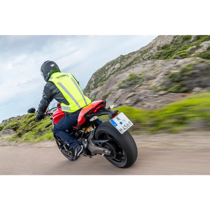 Motorcyclist in high-visibility vest riding red sports bike at Leks Motor Oslo