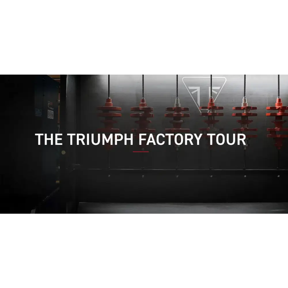Røde industrielle Triumph-motorer hengende i fabrikk under factory tour