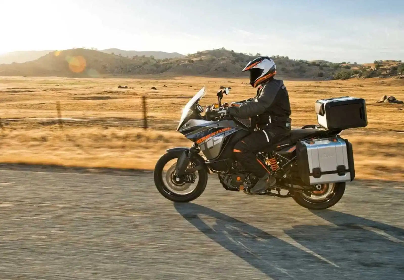 Motorsyklist på en touring-sykkel som kjører langs en vei.