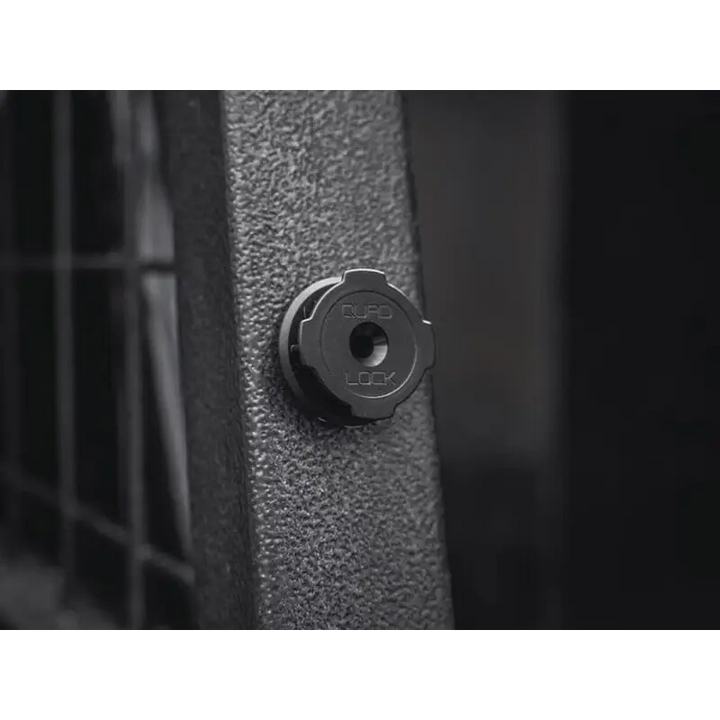 Svart rund komponent med QUAD LOCK preging for sikker montering av Quad Lock Adhesive Wall Mount