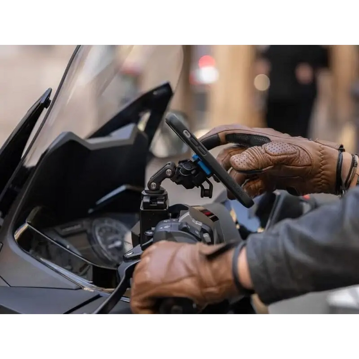 Motorcykelfører med hansker bruker Quad Lock Brake Reservoir Mount på styret