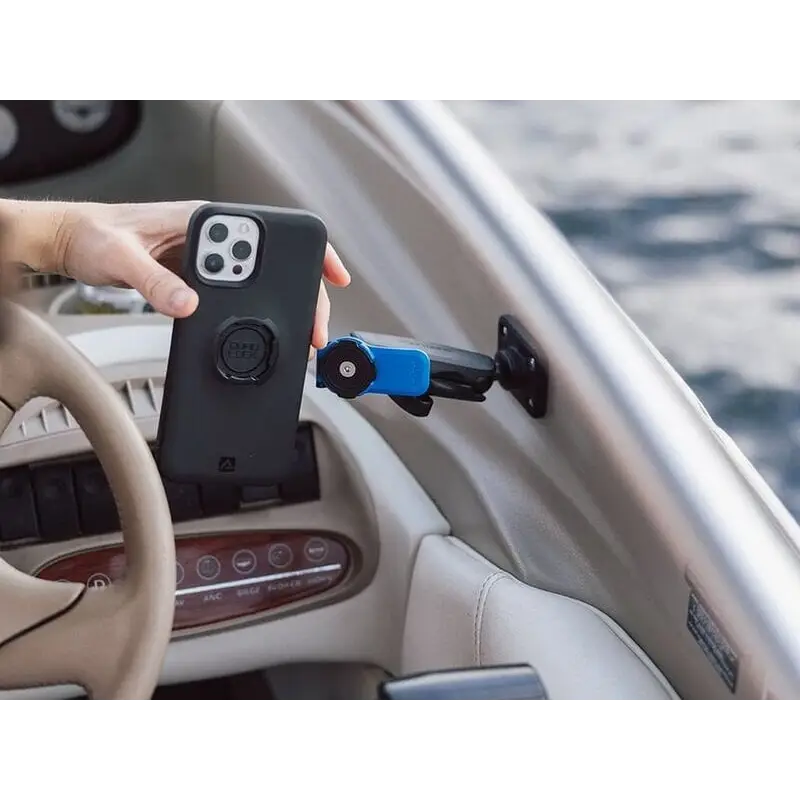Black smarttelefon i beskyttelsesdeksel med sirkulært feste nær båtdashboardholder