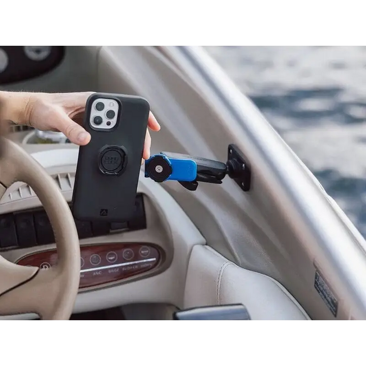Black smarttelefon i beskyttelsesdeksel med sirkulært feste nær båtdashboardholder