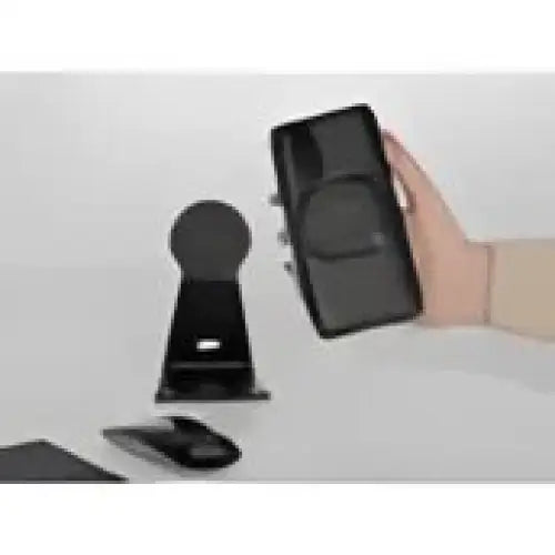 Black smarttelefon med etuiet holdt over matchende skrivebordsholder for Quad Lock MAG Universal Adaptor