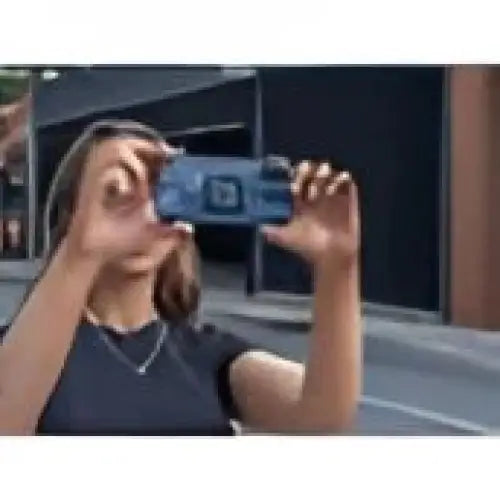 Person som holder en blå smarttelefon horisontalt for å ta foto eller video med Quad Lock Universal Adaptor